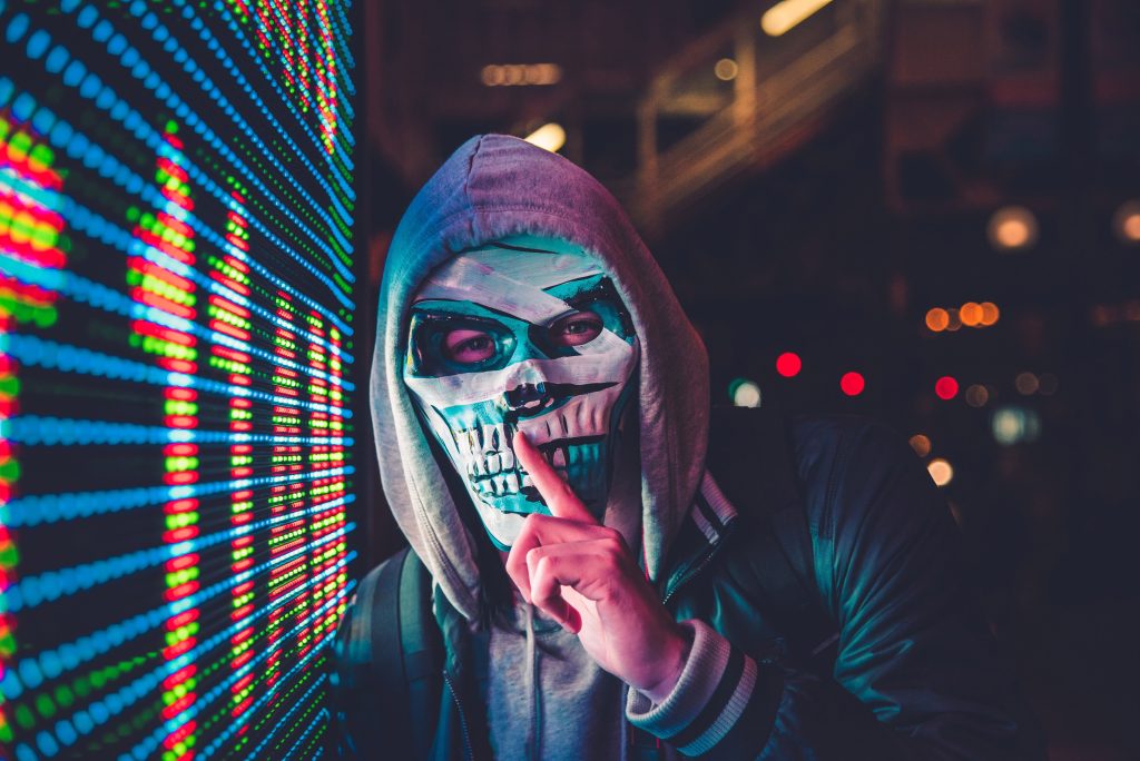 A man with a scary mask, near lights.